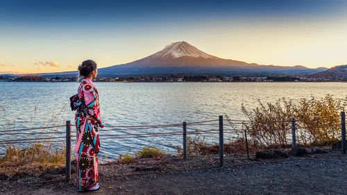 Woman wearing traditional clothes while standing by sea