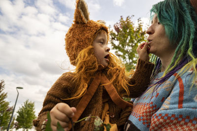 Mother carrying daughter at public park