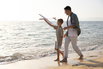 Rear view of couple standing at beach