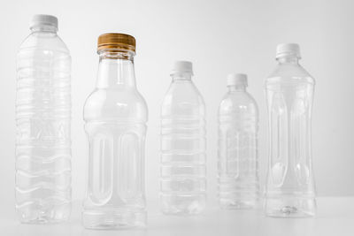 Close-up of empty bottles on table against white background