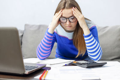 Portrait of young woman using laptop on table