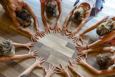 Group of friends practicing child pose with hands on floor