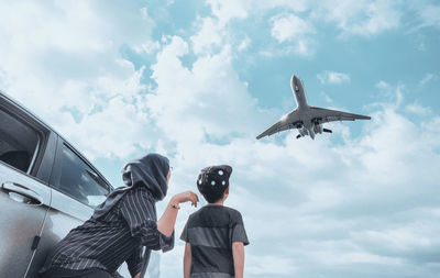 Low angle view of airplane flying against sky