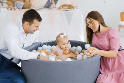 Happy family playing with colorful balloons in the children's room at home