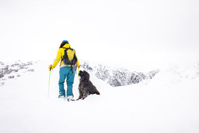 Rear view of person with umbrella on snow covered mountain