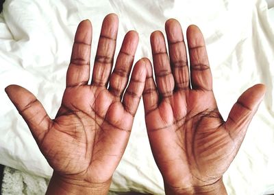 Cropped hands of person on white sheet