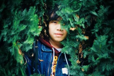 Woman standing by tree trunk