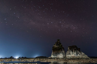 Low angle view of rock formation against sky at night