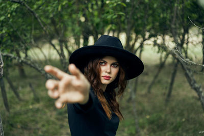 Portrait of young woman wearing hat standing outdoors