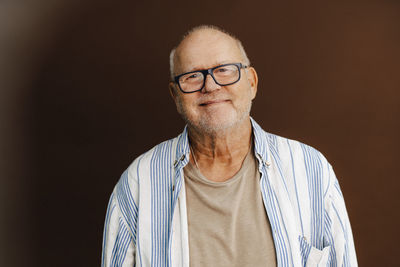 Portrait of smiling senior man in studio