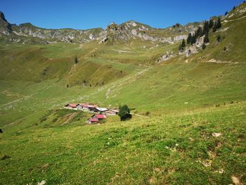 People on field by mountain against sky