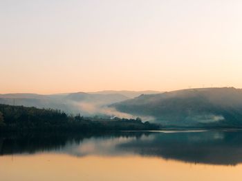 Scenic view of lake against clear sky during sunset