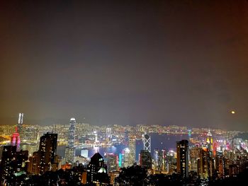 Illuminated cityscape against sky at night