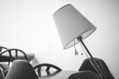 Close-up of lamp at table against wall