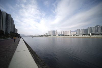City buildings by sea against sky