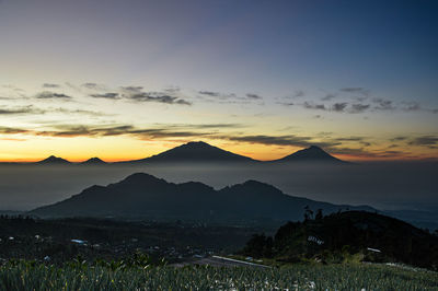 Scenic view of silhouette mountains against sky during sunset