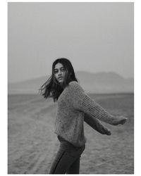 Portrait of smiling young woman standing in sea against sky