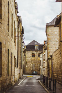 Street amidst houses against sky