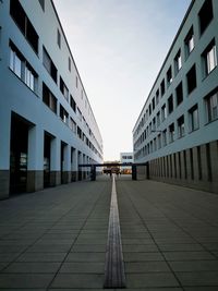 Footpath amidst buildings against sky in city