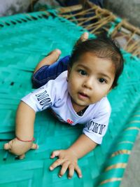 Portrait of baby boy relaxing on cot