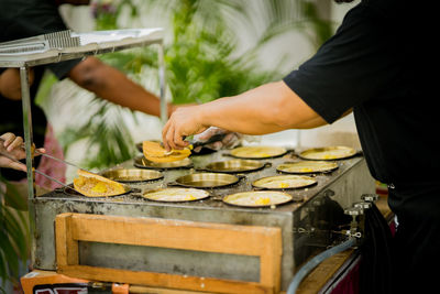 Midsection of man preparing food at market stall