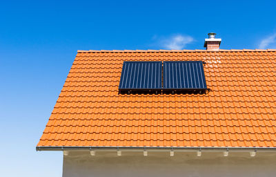 Low angle view of house roof against sky