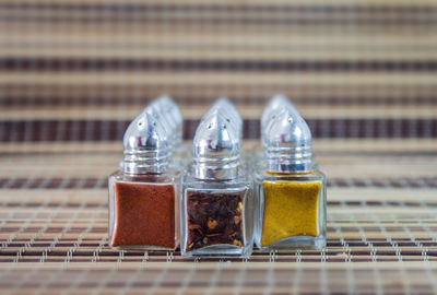 Close-up of spices arranged in glass containers on mat