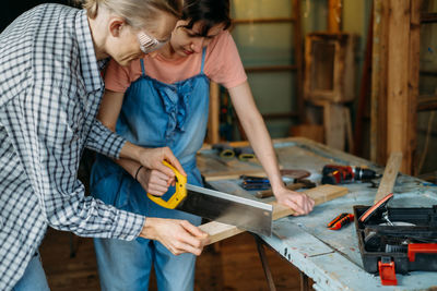 Man and woman working in workshop, doing furniture, reuse old materials to new product. awareness in