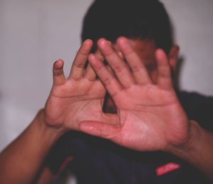 Close-up of hands covering face with hand