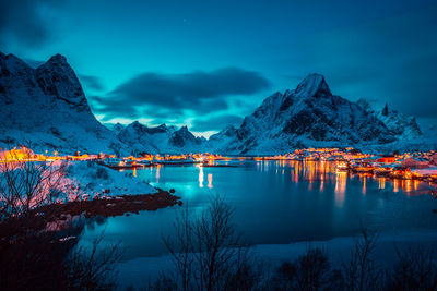 Scenic view of lake by snowcapped mountains against sky