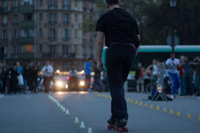 Rear view of man skating on road