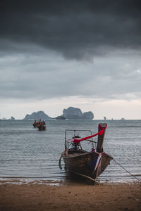 Boat moored on shore against sky