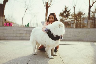 Young woman embracing dog outdoors