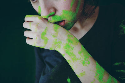 Close-up of midsection of woman with green powder paints