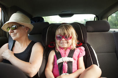 Grandmother and granddaughter sitting in car