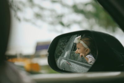 Little baby peeking outside car window 