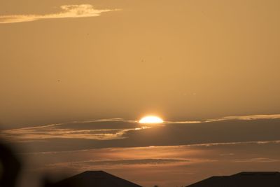 Scenic view of silhouette mountains against orange sky