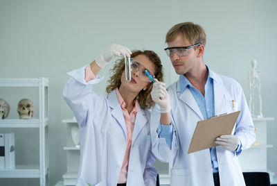 Young man wearing hat standing against wall