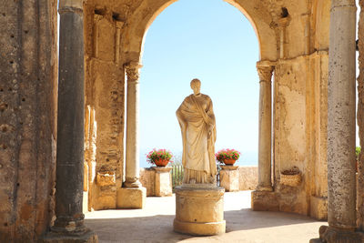 Rear view of buddha statue against historic building