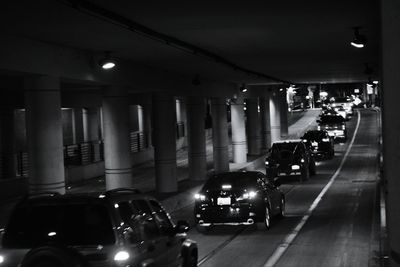 Cars on illuminated street in city at night