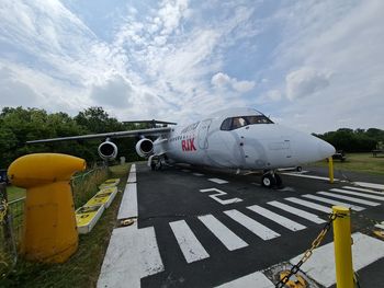 Airplane on runway against sky