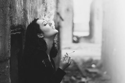 Side view portrait of woman smoking outdoors