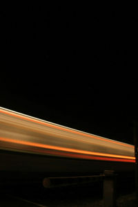 Low angle view of light trails against sky at night