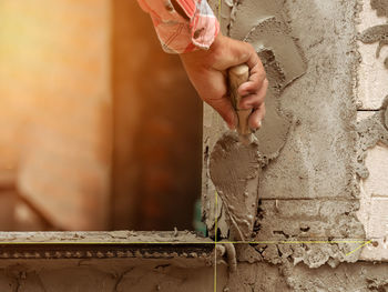 Midsection of woman working against wall