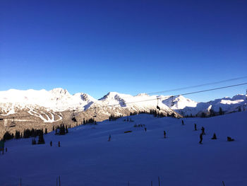 Scenic view of snowcapped mountains against blue sky