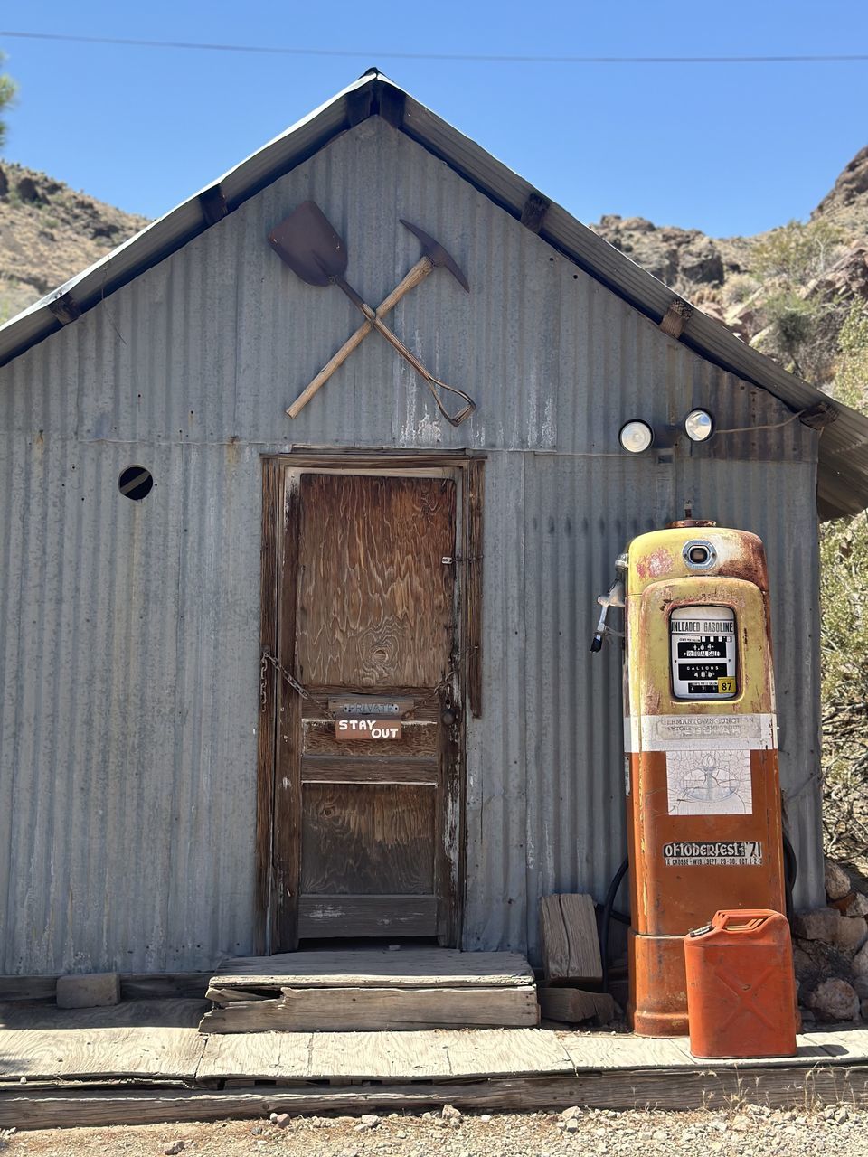 architecture, built structure, building exterior, building, no people, nature, shack, day, wood, sky, shed, door, entrance, outhouse, house, old, blue, outdoors, sunny, clear sky, closed, landscape, sunlight, rural scene