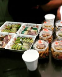 High angle view of cakes and cookies in containers on table