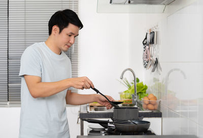 Side view of young man working at home