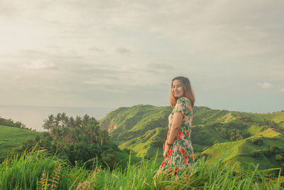 Woman standing on field against sky