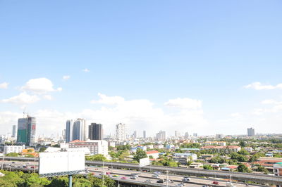 View of cityscape against cloudy sky